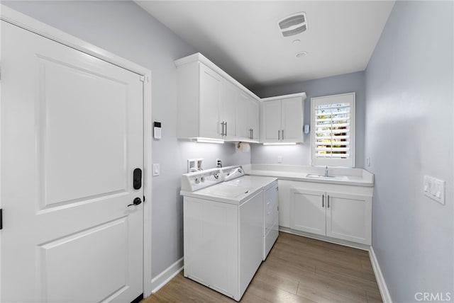 207 Via Galicia, San Clemente, CA 92672 - clothes washing area featuring washing machine and dryer, cabinet space, baseboards, and light wood finished floors