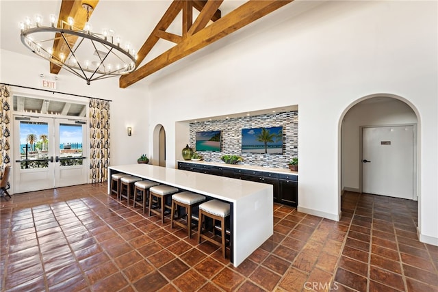 207 Via Galicia, San Clemente, CA 92672 - kitchen with arched walkways, high vaulted ceiling, a breakfast bar area, light countertops, and a chandelier