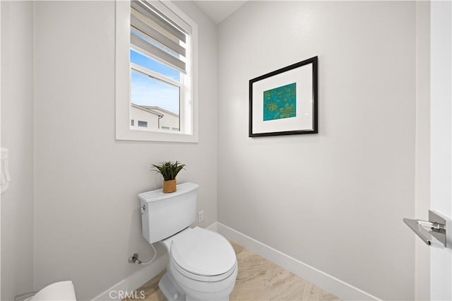 bathroom featuring baseboards and toilet