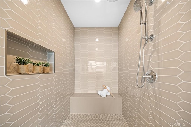 full bath featuring a tile shower and tile walls