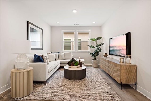 living area with baseboards, recessed lighting, wood finished floors, and visible vents