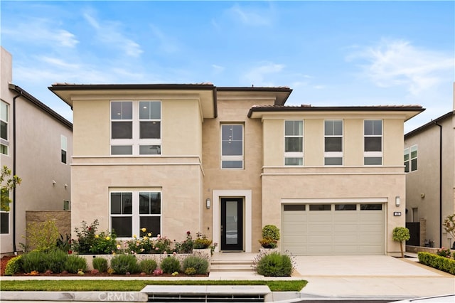view of front of property featuring an attached garage, stucco siding, and concrete driveway