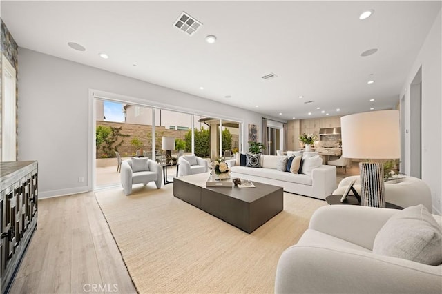 living area with recessed lighting, baseboards, light wood finished floors, and visible vents