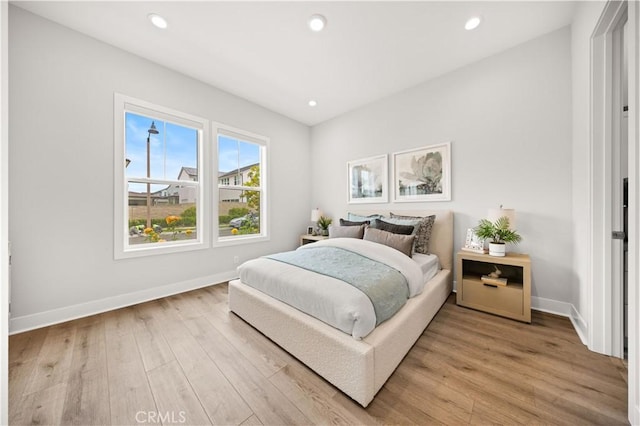 bedroom with baseboards, recessed lighting, and light wood finished floors
