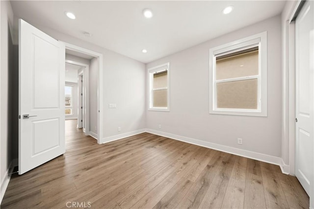 unfurnished bedroom with recessed lighting, baseboards, and light wood-type flooring