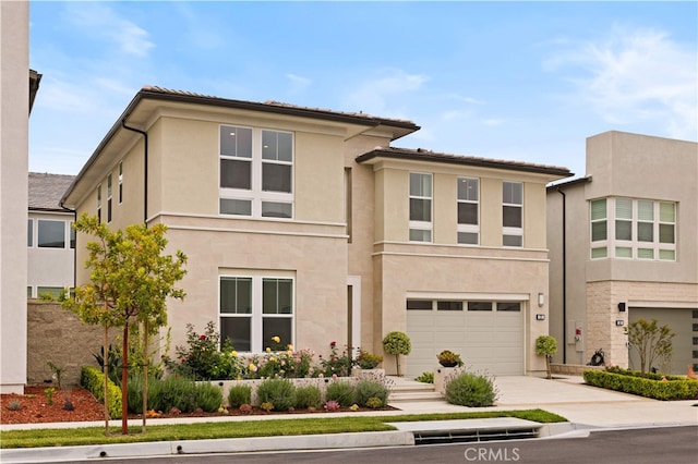 view of front of home with an attached garage, driveway, and stucco siding