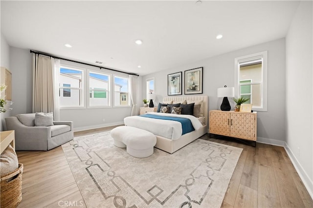 bedroom with baseboards, recessed lighting, wood finished floors, and visible vents