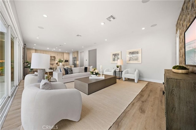 living area with visible vents, recessed lighting, baseboards, and light wood-type flooring