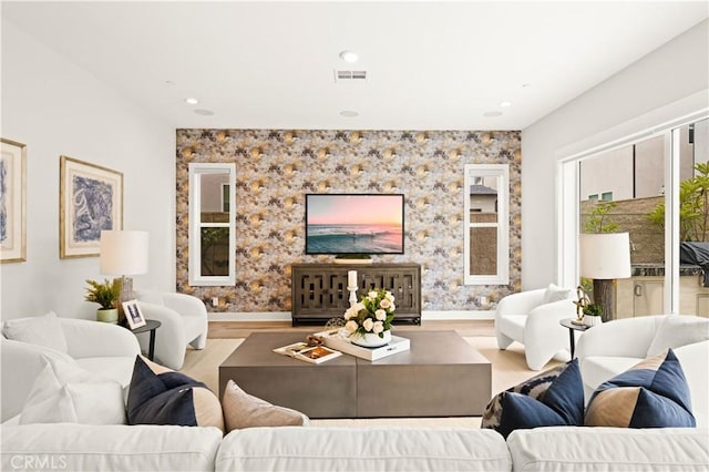 living room featuring baseboards, recessed lighting, wood finished floors, and visible vents