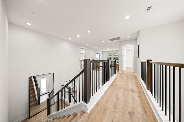 hall featuring recessed lighting, an upstairs landing, light wood-style flooring, and visible vents