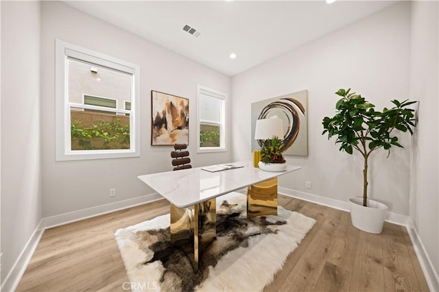 office featuring baseboards, visible vents, and light wood finished floors
