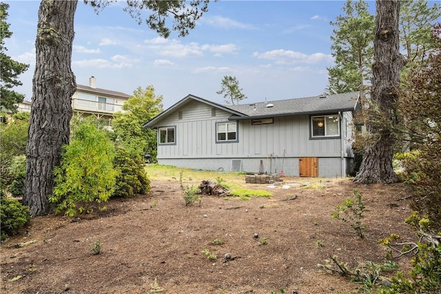 back of house featuring a shingled roof