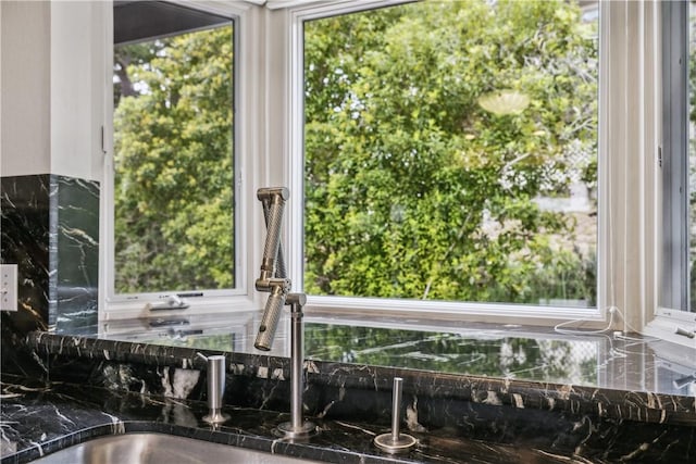 interior details with dark countertops and tasteful backsplash