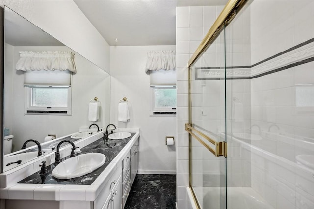 bathroom featuring a sink, baseboards, a shower with door, and marble finish floor