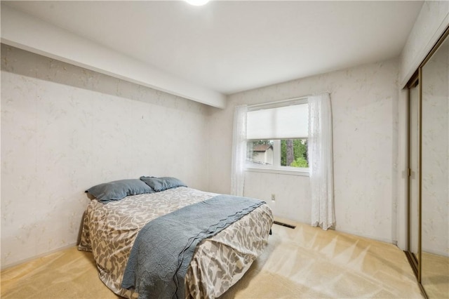 carpeted bedroom featuring a closet and visible vents