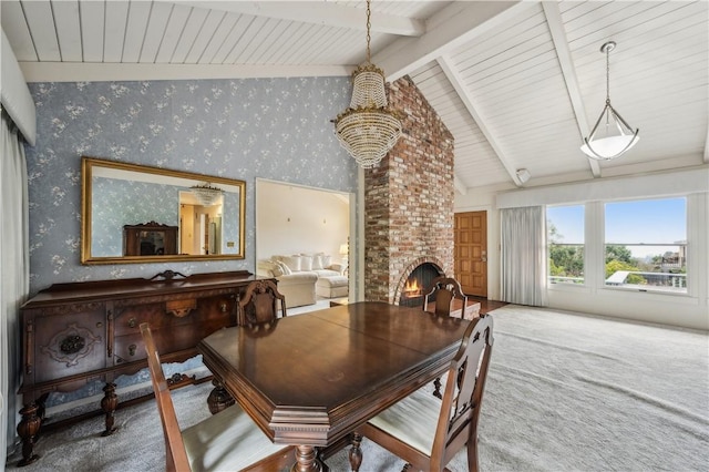 dining space featuring carpet flooring, lofted ceiling with beams, a fireplace, wallpapered walls, and wooden ceiling