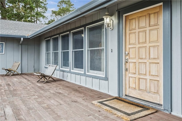 property entrance featuring roof with shingles and board and batten siding