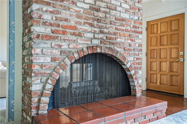 interior details featuring a brick fireplace