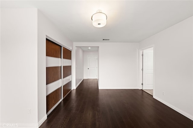interior space with visible vents, baseboards, and dark wood-style floors