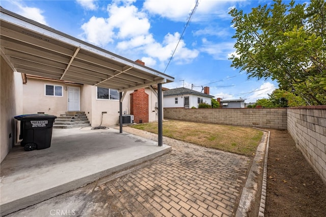 view of patio featuring a fenced backyard, entry steps, and central AC unit
