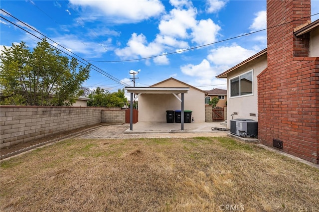 view of yard featuring a patio, a fenced backyard, and central air condition unit