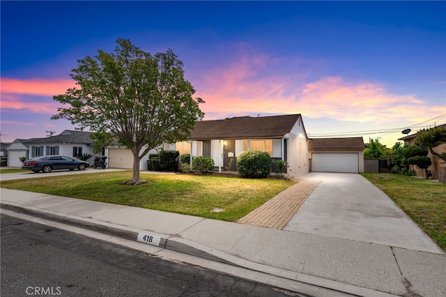 ranch-style home with a lawn, a garage, stucco siding, and driveway