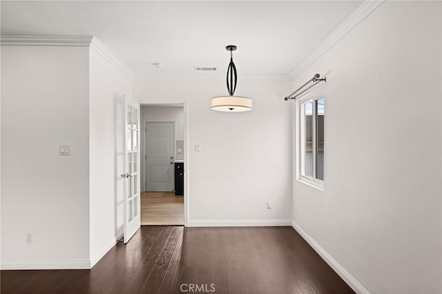 unfurnished dining area with visible vents, baseboards, crown molding, and dark wood-style floors
