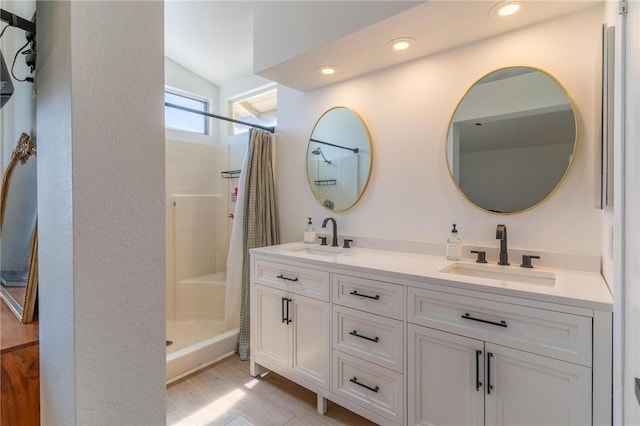 full bath featuring double vanity, a sink, curtained shower, and vaulted ceiling