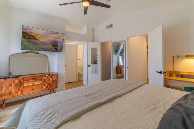 bedroom with a ceiling fan, lofted ceiling, connected bathroom, and visible vents