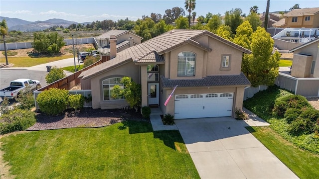 view of front of home featuring a garage, a tiled roof, concrete driveway, and stucco siding
