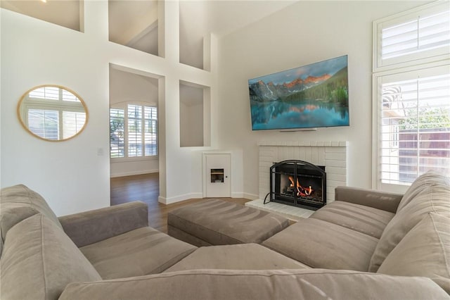26928 Eagle Run St, Corona, CA 92883 - living room featuring a brick fireplace, baseboards, wood finished floors, and a high ceiling