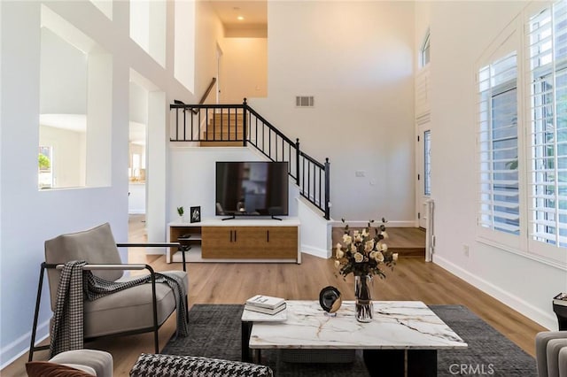 26928 Eagle Run St, Corona, CA 92883 - living area featuring a towering ceiling, stairs, wood finished floors, and baseboards