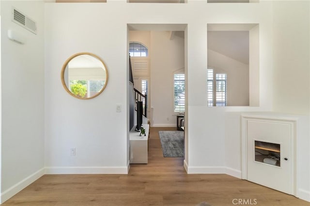 foyer entrance with stairway, plenty of natural light, wood finished floors, and visible vents