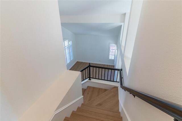 staircase with baseboards and wood finished floors