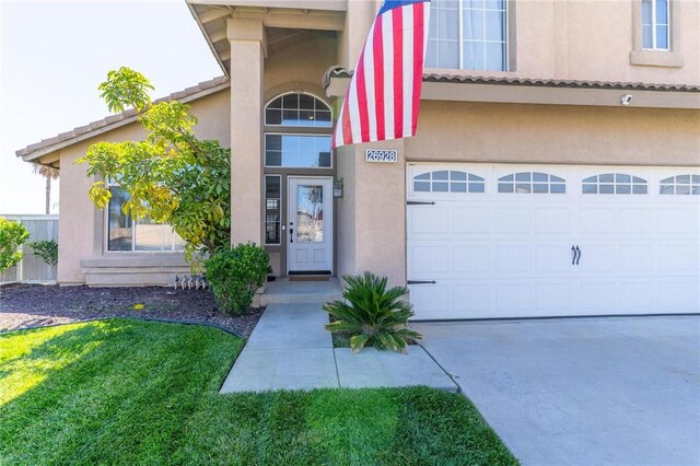 doorway to property with a garage, stucco siding, driveway, and a tile roof