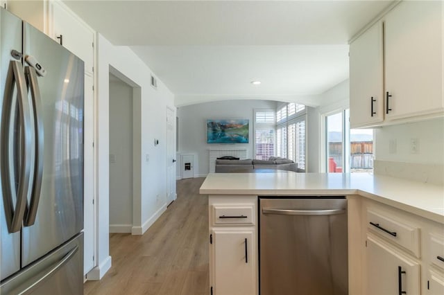 kitchen with visible vents, light countertops, light wood-style flooring, and stainless steel appliances