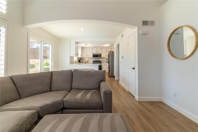 26928 Eagle Run St, Corona, CA 92883 - living room with light wood-style flooring, baseboards, and arched walkways
