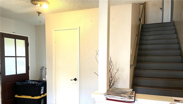staircase featuring a textured ceiling