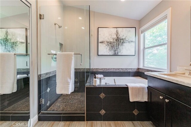 56 Egret Ln, Aliso Viejo, CA 92656 - bathroom featuring a stall shower, vanity, a bath, and vaulted ceiling