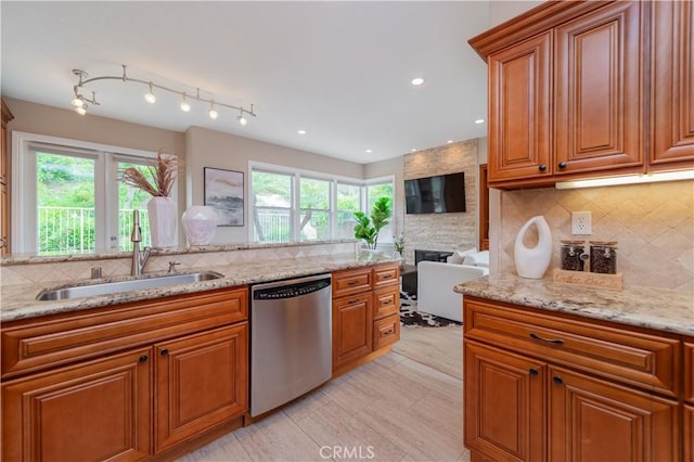 kitchen with a sink, decorative backsplash, dishwasher, and brown cabinets