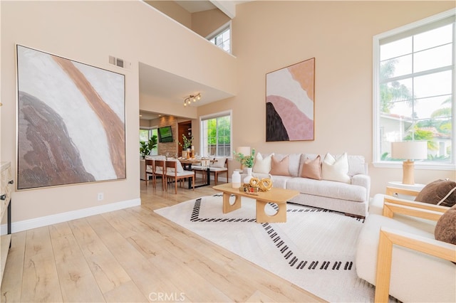 living room with visible vents, baseboards, and wood finished floors