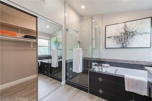 bathroom with recessed lighting, a shower stall, wood finished floors, and a bath