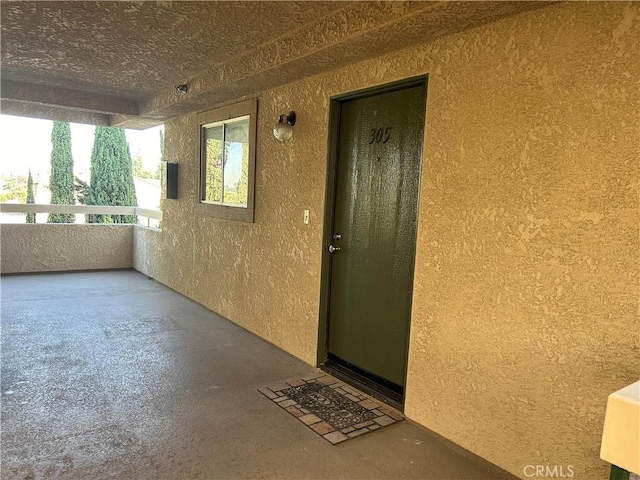 12121 Centralia St Unit 305, Lakewood, CA 90715 - doorway to property featuring a balcony and stucco siding