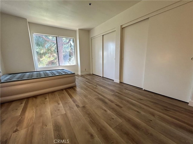 12121 Centralia St Unit 305, Lakewood, CA 90715 - unfurnished bedroom with multiple closets and wood finished floors