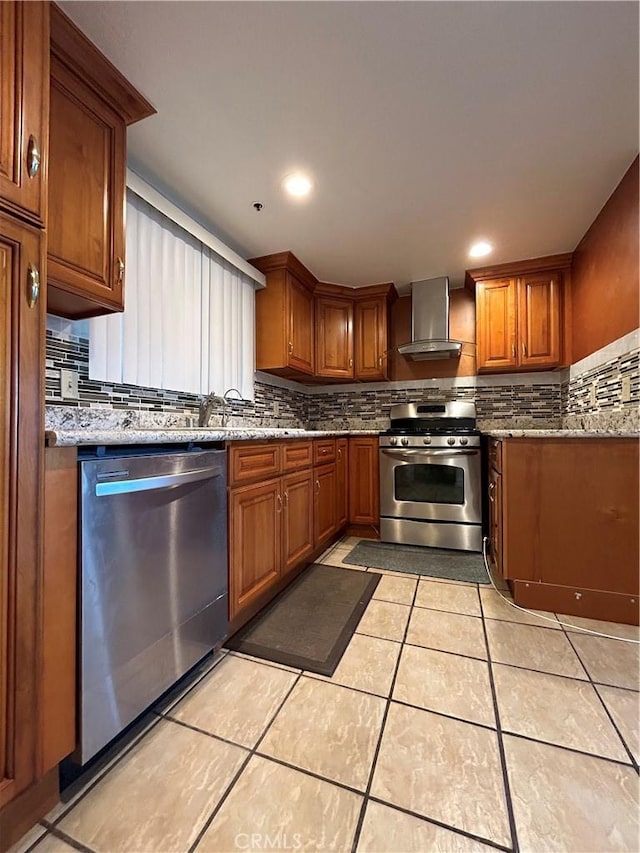 12121 Centralia St Unit 305, Lakewood, CA 90715 - kitchen featuring wall chimney range hood, appliances with stainless steel finishes, tasteful backsplash, brown cabinets, and light tile patterned flooring