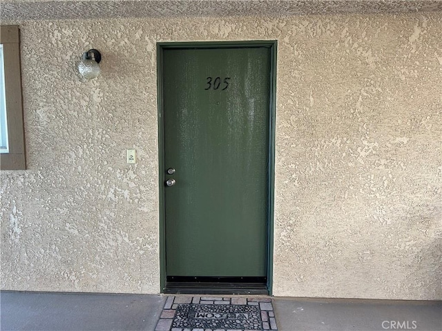 12121 Centralia St Unit 305, Lakewood, CA 90715 - doorway to property featuring stucco siding