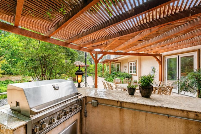 view of patio / terrace with an outdoor kitchen, a pergola, and area for grilling