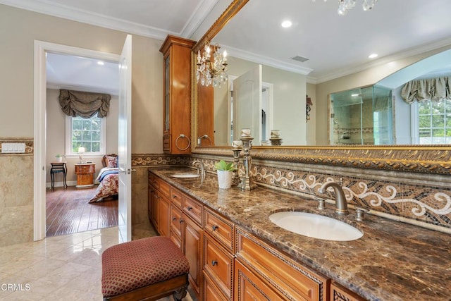 bathroom with double vanity, visible vents, ornamental molding, and a sink