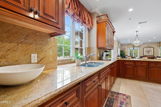 kitchen featuring crown molding, recessed lighting, plenty of natural light, and a sink