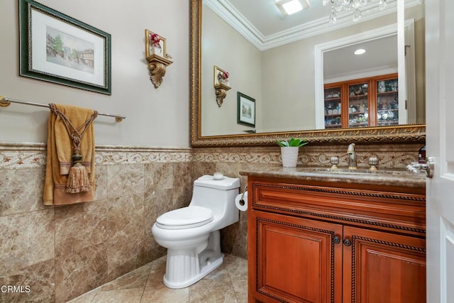 half bathroom featuring vanity, ornamental molding, tile patterned flooring, toilet, and tile walls